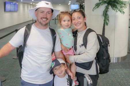 Happy family of four waiting at Mears Connect at MCO